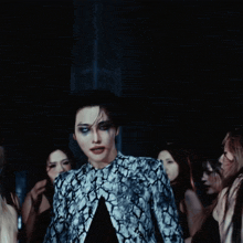 a man in a snake print jacket is surrounded by women