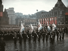 a group of people marching in a parade with a red banner that says ' soviet union ' on it