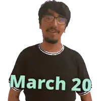 a man wearing glasses and a black shirt with march 20 on it