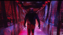 a man in a clown costume is walking through a tunnel