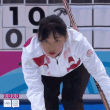 a woman in a white and red jacket stands in front of a scoreboard with the number 10 on it