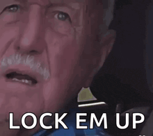 a close up of a man 's face with the words lock em up written on it