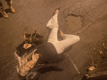 a woman laying on the ground with a purse in her hand