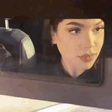 a close up of a woman 's face looking out of a car window