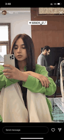 a woman is taking a picture of herself in a mirror with a message that says karachi on it