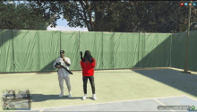 a man and a woman are standing on a tennis court with a green fence behind them