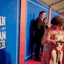 a group of people standing on a red carpet in front of a blue wall that says ' n ' on it