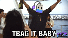 a man with a tea bag on his head holds a bottle of champagne in his hand and says tbag it baby