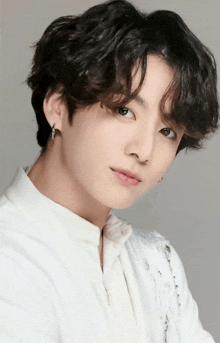 a close up of a young man wearing a white shirt