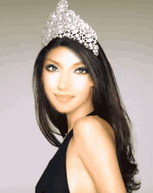 a woman wearing a tiara on her head looks at the camera