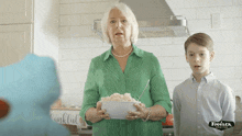 a woman in a green shirt is holding a bowl of food next to a boy and a sign that says thankful