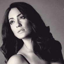 a black and white photo of a woman with long hair and earrings