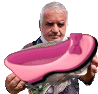 a man holds a pink shoe with a bow on it