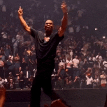 a man in a black shirt is dancing in front of a crowd of people