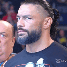 a man with a beard is wearing a black t-shirt that says w liv on it .