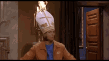 a man wearing a bishop 's hat is standing in front of a door