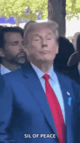 a man in a suit and tie is standing in a crowd .