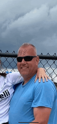 a man with a tattoo on his forehead is standing next to a girl .