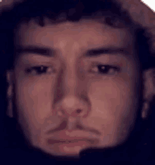 a close up of a man 's face with a beard and a hat .