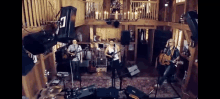 a band is playing music in a barn with candles on the ceiling .