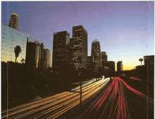 a long exposure photo of a city skyline with a highway in the foreground