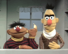 two sesame street characters are standing next to each other and one is holding a banana