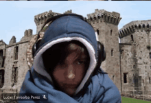 lucas torrealba perez is wearing headphones in front of a stone castle