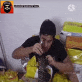 a man is eating a bag of chips and drinking a bottle