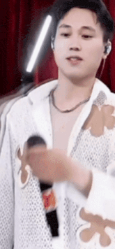 a man in a white shirt is holding a microphone .