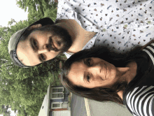 a man and a woman are posing for a picture in front of a house with a garage door