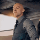 a bald man wearing a suit and tie is looking at the camera
