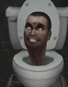 a man is sitting on a toilet with his head sticking out of it .