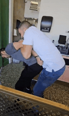 two men are fighting in a room in a restaurant .