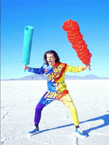 a man wearing a colorful jumpsuit with the word taco on the front