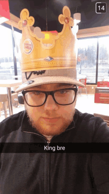 a man wearing glasses and a burger king crown says king bre