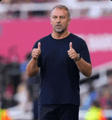 a man in a blue shirt is giving a thumbs up sign