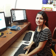 a woman sits at a desk in front of a computer with a sign on the wall that says local