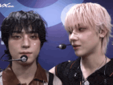 a man with a tic on his nose stands next to another man