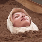a person with a hood on their head is buried in the dirt