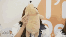 a girl is making a funny face while holding a stuffed animal .