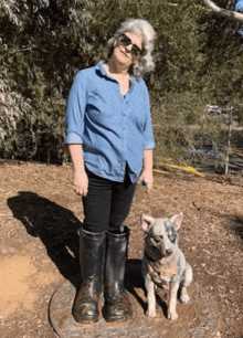 a woman standing next to a statue of boots and a dog