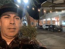 a man wearing a cowboy hat takes a selfie in front of a building