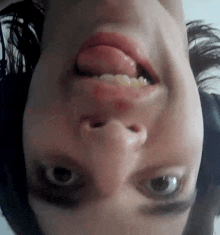 a woman 's face is upside down with her tongue sticking out