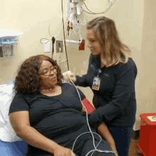 a woman with a name tag that says ' nurse ' on it is talking to a woman in a hospital bed