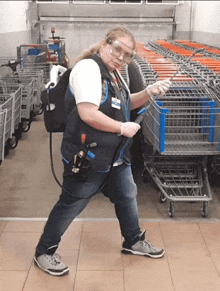 a woman wearing a walmart vest and goggles is spraying a cart