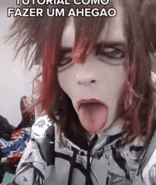 a person with long red hair is sticking their tongue out .