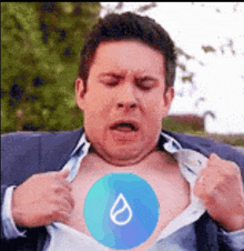 a man is taking off his shirt to reveal a drop of water on his chest