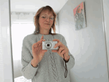 a woman is taking a picture of herself with a camera