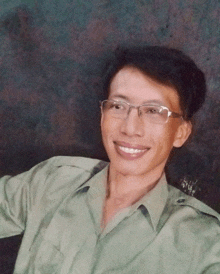 a man wearing glasses and a green shirt is smiling