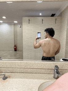 a man taking a picture of his back in a bathroom